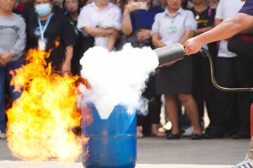 Employees firefighting training, Concept Employees hand using fire extinguisher fighting fire...