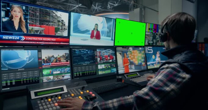 Backstage View of a Tv Station Production Control Room With Green Screen Chroma Key Mock-up Displays. a White Male Technician Cues Sources, Monitors Multiviews, and Times Live Newsroom Output.