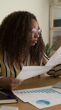 Stressed black businesswoman reviewing financial documents