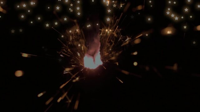 Sparkler tip igniting, glowing core emitting radial sparks and flame, producing starry bokeh burst