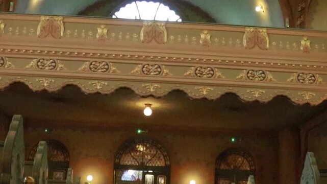 Cinematic extreme low angle view of stone pillar and wooden balcony in historic synagogue