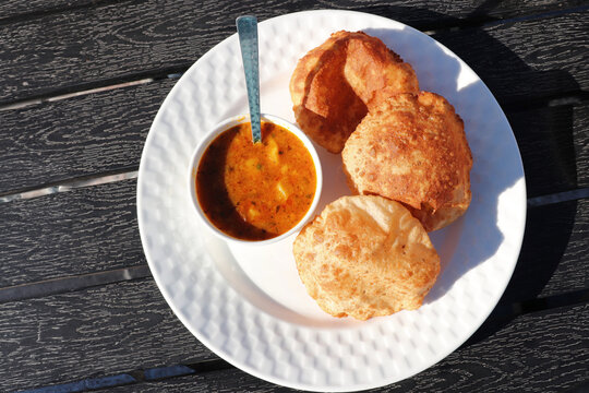 Indian cuisine Puri Bhaji. It is a traditional breakfast dish in North India. Puri is a deep fried bread made from whole wheat flour and Served with spicy Potato curry called bhaji or alu ki sabji.