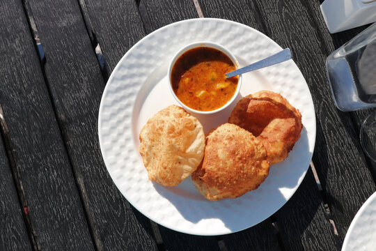Indian cuisine Puri Bhaji. It is a traditional breakfast dish in North India. Puri is a deep fried bread made from whole wheat flour and Served with spicy Potato curry called bhaji or alu ki sabji.