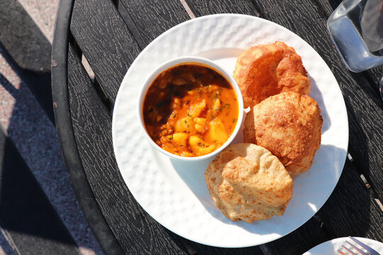 Indian cuisine Puri Bhaji. It is a traditional breakfast dish in North India. Puri is a deep fried bread made from whole wheat flour and Served with spicy Potato curry called bhaji or alu ki sabji.