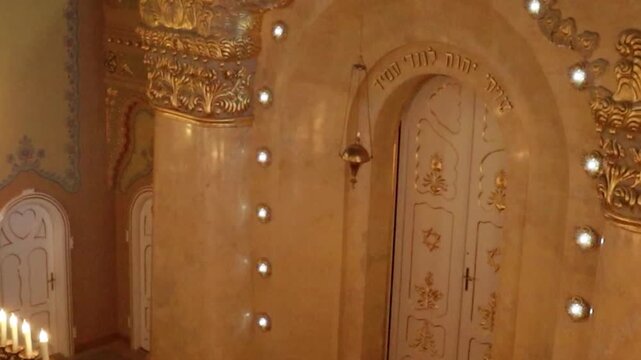 Cinematic tilt down of historic synagogue entrance with Star of David, detailed carving and multi-bulb chandelier