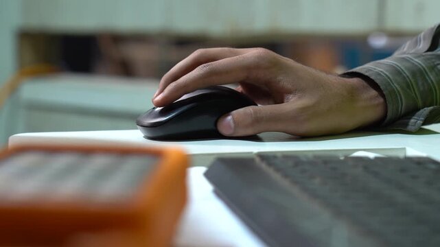 CNC Machine Technician Using A Computer Mouse To Program A Procedure In A Industrial Metal Workshop.