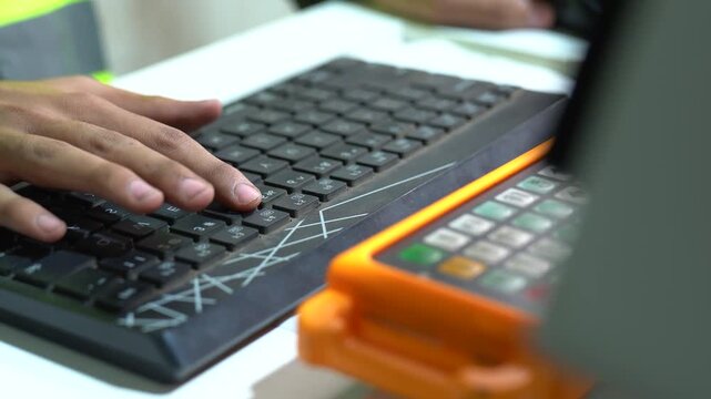 CNC Machinist Programming A Automated Program For Manufacturing In A Metalworking Facility, Close Up Shot.