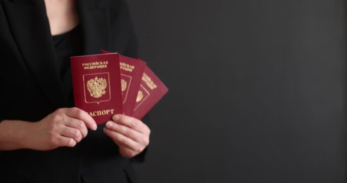 A red Russian passport held by a woman against a dark background. Russia, Izhevsk, March 14, 2026.
