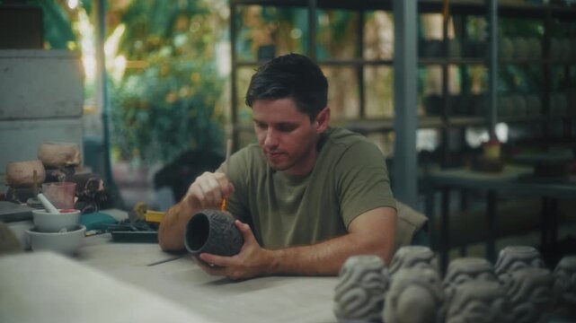 Passionate Male Ceramic Artist Meticulously Molds And Embellishes Vessels During Sunny Outdoor Sessions