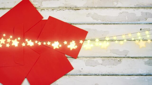 Animation of string lights over red envelopes on painted wood boards