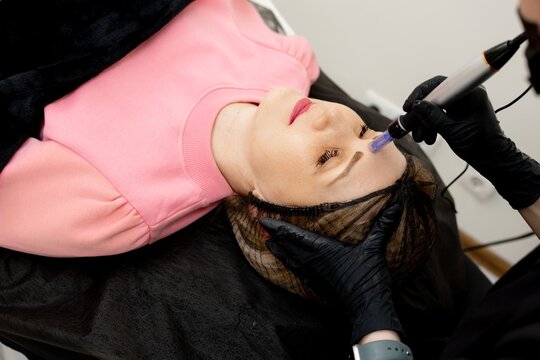  Peeling, women's health care, skin regeneration, microneedling dermapen, dermastamp. Cosmetologist-conducts the procedure of fractional microneedling clinic for the face. Facial rejuvenation
