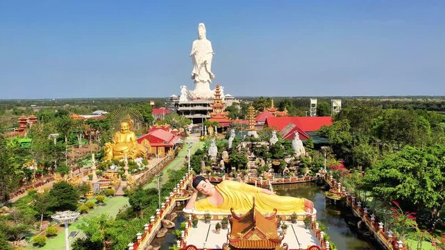 Diagonal 4K aerial sweep showcasing the three iconic Buddha monuments and the grand architecture of Van Phuoc Pagoda.