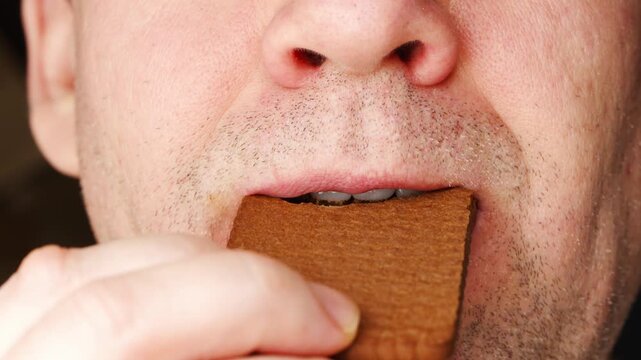 Man eats chocolate cookie and shows different facial expressions