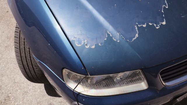 Peeling car paint - sun worn paint. Weather damage of car.