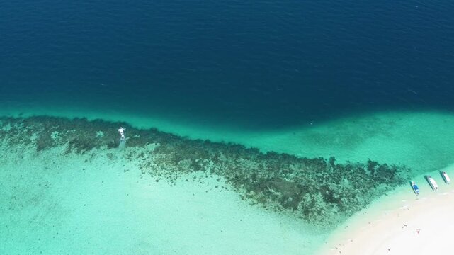 Aerial drone footage of Bamboo Island near Phi Phi Islands showing turquoise water, coral reefs, longtail boats and white sand beaches.