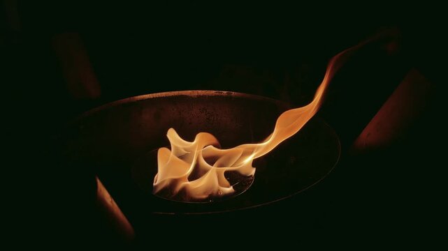 Burning flame in metal container with dark night 