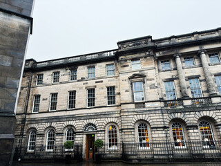 Naklejka premium Historic stone Georgian building facade in West Parliament Square, Edinburgh, Scotland, UK with arched windows and classical columns on a rainy day