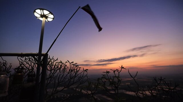 Natural video background of a high-angle atmosphere on a mountain that overlooks the surrounding scenery(mountains, trees,sea)from a scenic vantage point,with a wooden chair for sitting and resting