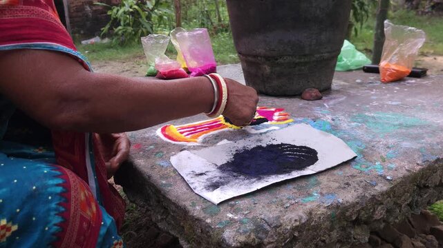 Woman hand creating traditional rangoli with colored powder on floor, Odia folk art design with vibrant patterns, cultural decoration for festivals, showing Indian tradition, creativity heritage art