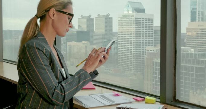 Businesswoman Analyzing Data on Tablet in Office Skyline