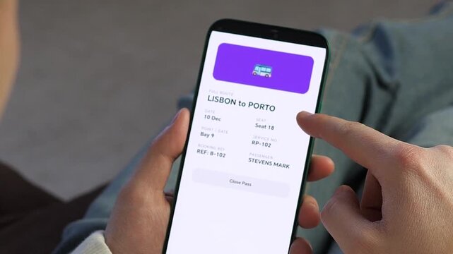 Person checking digital bus ticket on smartphone. Modern traveler uses a mobile app to view an electronic bus pass from Lisbon to Porto. High-quality UI shows seat and booking details. 