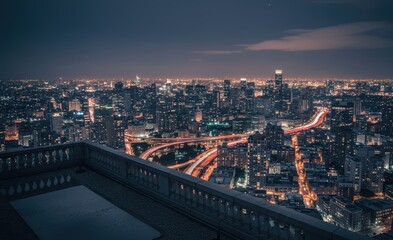 Naklejka premium Panoramic night view of a modern cityscape from a high rooftop, showing illuminated buildings and busy roads