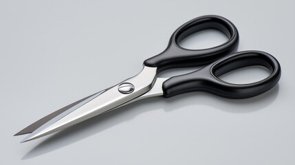 Fototapeta premium A pair of open scissors with black handles rests on a plain surface