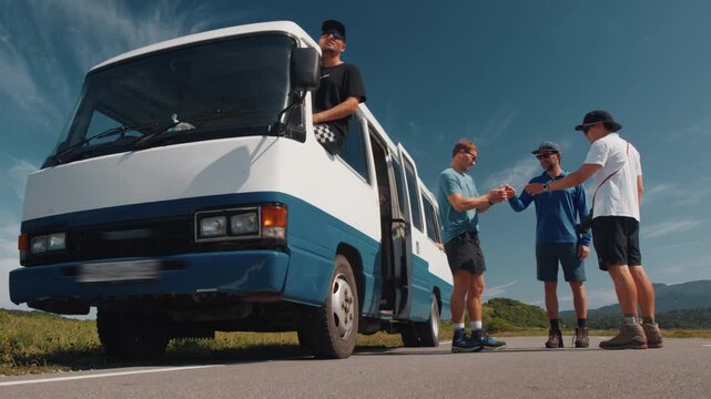 Group of people travel on the retro bus and have small rest on the road