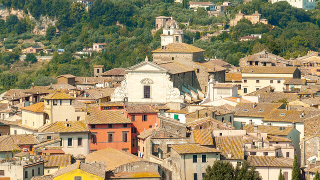 Aerial panorama of Orte town in Lazio Italy summer. Drone shot of medieval historical buildings on a tuff hill with green forest background. Italian travel and tourism concept