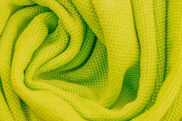 Bright neon green cotton fabric swirled into a dynamic spiral pattern. The vivid lime lime texture...