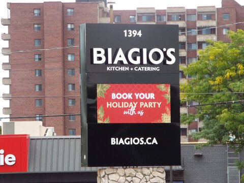 Ottawa, Ontario, Canada-July 22, 2025: A modern pylon sign for "Biagio's Kitchen + Catering" features a digital display promoting holiday party bookings on Richmond Rd.