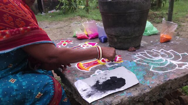 Making rangoli design using colored powders by woman hand, traditional Indian folk art on floor with mandala patterns, vibrant cultural decoration for festivals like Diwali, representing creativity