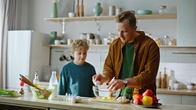 Caring father teaching culinary little attentive son standing kitchen closeup.