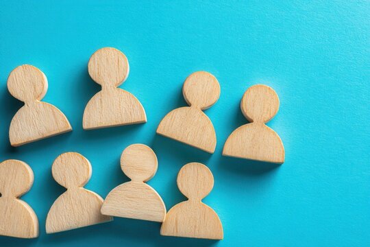 Wooden Figures on Blue: A close-up shot captures an array of wooden figure cutouts arranged on a striking blue surface, evoking ideas of community and human connection.