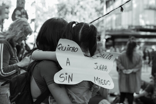 Madre e hija abrazadas en la marcha de los derechos por las mujeres con un cartel en protesta. 8m, derechos, feminista 