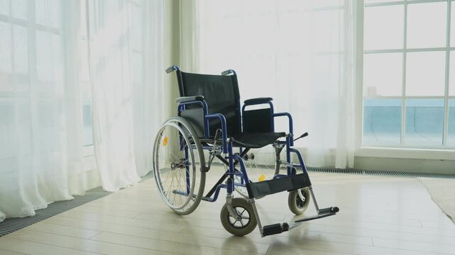 Empty wheelchair waiting for patient services in living room retirement home hospital. Chair for people with disability at home. Handicap accessible symbol. Health care medical lonely elderly sick
