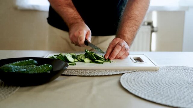 Learn how to slice cucumbers for salads and snacks in a simple kitchen setting