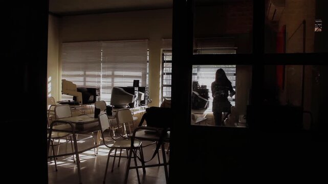 Person Closing Window Blinds in Empty Classroom, Silhouette Seen Through School Door, Argentina - 4K