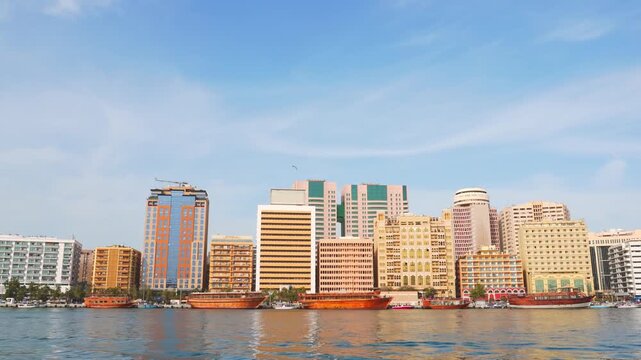 Dubai, UAE - 16th january, 2026: timelapse zoom in Deira waterfront at Dubai Creek. Traditional dhow boats line the quay beneath landmarks like the Pearl Creek Hotel in the heart of Dubai trading hub
