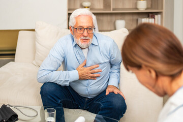 Obraz premium Female doctor examining older senior man in doctor office or at home. Old man patient and doctor have consultation in hospital room. Medicine healthcare medical checkup. Visit to doctor
