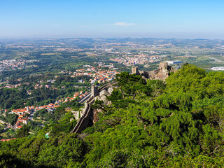 Obraz premium Castle of the Moors or Castelo dos Mouros is hilltop medieval castle located in the Sintra Mountains, in Portuguese Riviera. Forested area completely surrounding famous part of the reconstructed wall.