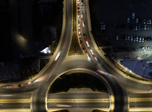 Drone aerial of cars move in different directions at a roundabout in a city during the night. Rush hour, energy, traffic, success, speed, fast. Nicosia Cyprus