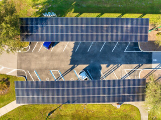 Photovoltaic canopy over parking area producing renewable electricity. Solar panels provide shade for vehicles while generating sustainable energy integrated into city infrastructure. © bilanol