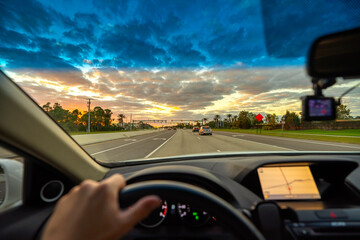 POV commute through rural town district, dashboard visible, cars merging at intersection, street...