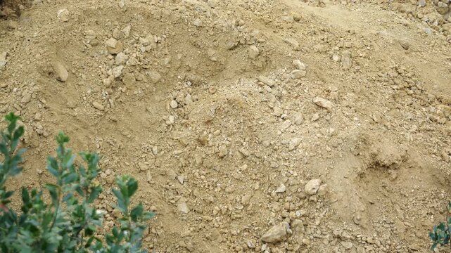 A backhoe excavator performing a lifting operation during earthworks. This showcases the versatility of excavators, which can be used for both digging and material handling tasks