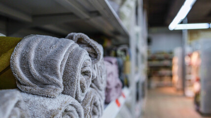 Soft, plush blankets rolled and neatly stacked on a store shelf, ready for purchase © shine.graphics