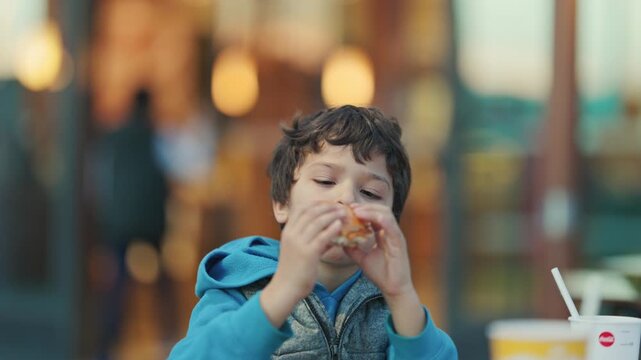 Cute little boy enjoying a burger