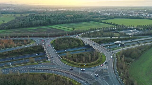 drone footage of vehicles traveling through a complex highway interchange on Ireland&rsquo;s N4 road at dusk. The contrast between structured roads and natural green surroundings highlights modern