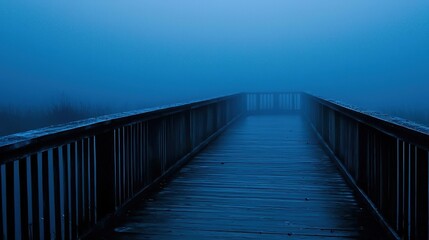 Fototapeta premium A wooden bridge with a railing and foggy background.