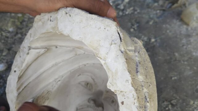 Close-up of a skilled artisan shaping a fibre sculpture using a power tool in a workshop, captured in slow motion. The scene highlights precision craftsmanship, manual labor, India